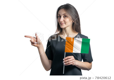 Happy young white woman holding flag Cote d'Ivoire and points to the left isolated on a white background Happy young white woman holding flag Cote d'Ivoire and points to the left isolated on a white background 78420612