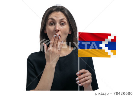 Happy young white woman holding flag of Nagorno-Karabakh Republic and covers her mouth with her hand isolated on a white background 78420680