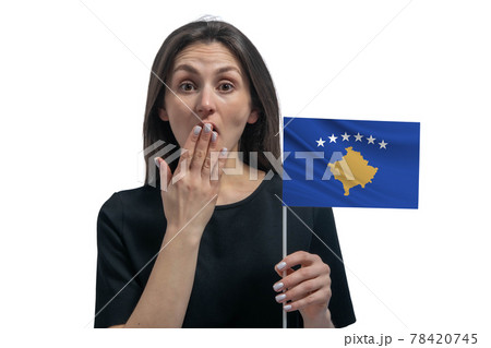 Happy young white woman holding flag of Kosovo and covers her mouth with her hand isolated on a white background 78420745