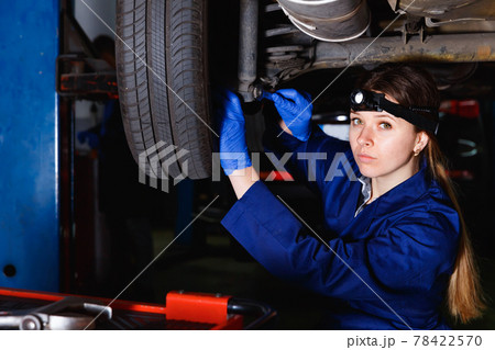 Young woman master is repairing car in workshop. Young woman master is repairing car in workshop. 78422570