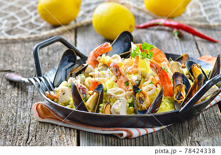 Tasty Spanish paella with seafood and chicken breast, served in a pan Tasty Spanish paella with seafood and chicken breast, served in a pan 78424338