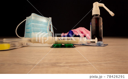 Different coloured pills stand on brown wooden table Different coloured pills stand on brown wooden table 78426291