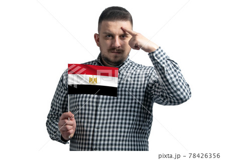 White guy holding a flag of Egypt and a finger touches the temple on the head isolated on a white background 78426356