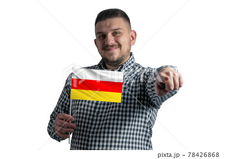 White guy holding a flag of South Ossetia and points forward in front of him isolated on a white background White guy holding a flag of South Ossetia and points forward in front of him isolated on a white background 78426868