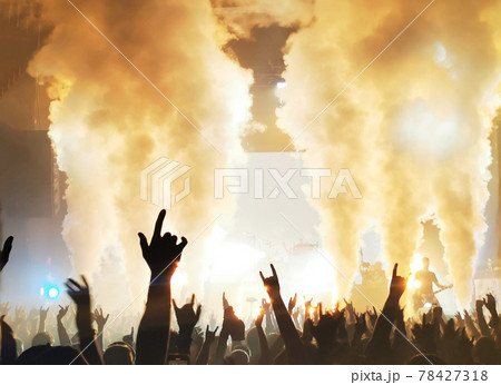 silhouettes of concert crowd in front of bright stage lights 78427318