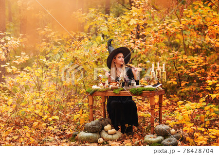 Young witch writing spells in forest Young witch writing spells in forest 78428704