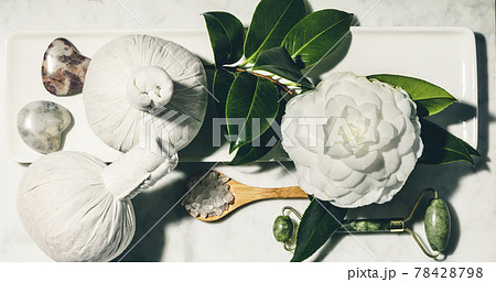 Flat lay composition with spring camelia flower and various beauty care products on white marble table 78428798