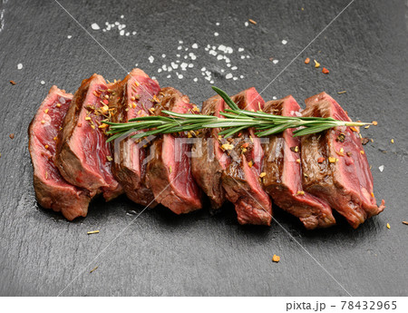 sliced fried beef steak New York striploin on a black background with spices, degree of doneness rare sliced fried beef steak New York striploin on a black background with spices, degree of doneness rare 78432965