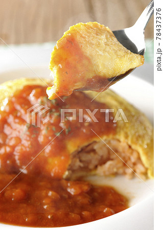 ミートソースのかかった熱々オムライスを一口食べる 78437376