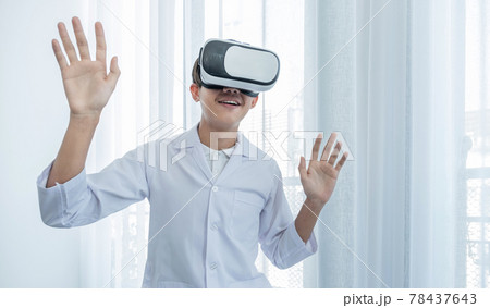VR box. A young Asian man in a doctor's uniform makes an excited expression while learning 78437643