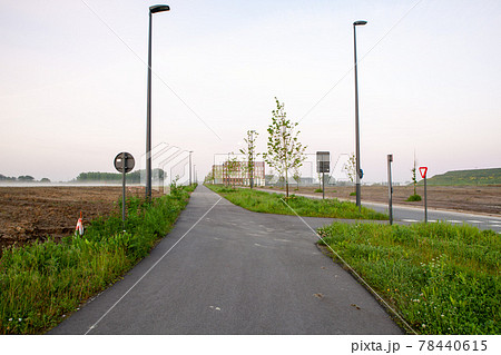 Street in the landscape and in the end a big building 78440615