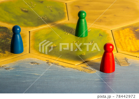 Three colored chips on yellow game board 78442972