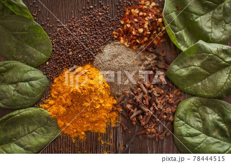 Sorted spices on dark wood background, seasonings for food. Top view of curry, paprika, pepper, cloves, bay leaf, turmeric, spices concept. Sorted spices on dark wood background, seasonings for food. Top view of curry, paprika, pepper, cloves, bay leaf, turmeric, spices concept. 78444515