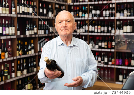 Portrait of senior man visiting winehouse in search of bottle of good wine 78444939