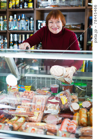 seller woman offering sausage products seller woman offering sausage products 78445466
