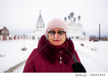 Elderly woman with glasses on background of Resurrection Monastery in Murom in winter 78445483