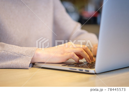 The girl in the cafe works at a laptop. 78445573