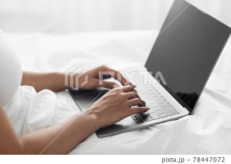 Remote work from home. African american lady typing on laptop with empty screen in bed, close up, free space Remote work from home. African american lady typing on laptop with empty screen in bed, close up, free space 78447072