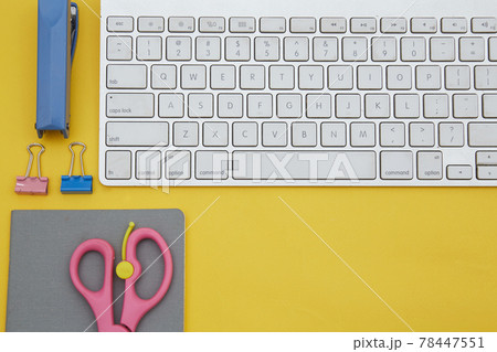 Digital learning concept. Top view of notebook and school suppliers and wireless keyboard isolated on yellow Digital learning concept. Top view of notebook and school suppliers and wireless keyboard isolated on yellow 78447551