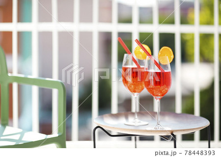 Two orange cocktails with straw on wooden table Two orange cocktails with straw on wooden table 78448393