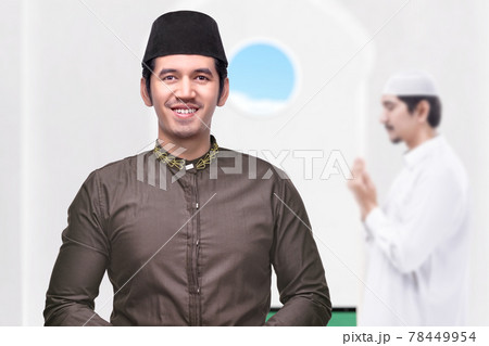 Asian Muslim man standing while raised hands and praying Asian Muslim man standing while raised hands and praying 78449954