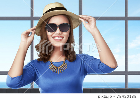 Asian woman standing with hat and sunglasses on the resort 78450138