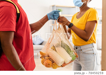 Supermarket Courier Delivering Products To African American Female At Home 78450259