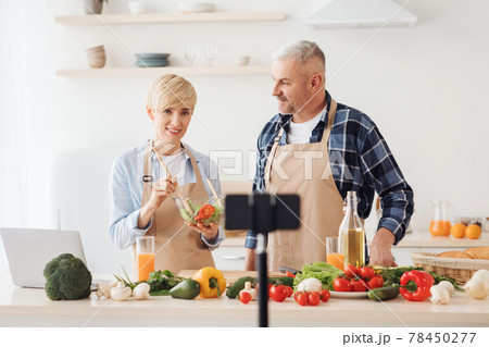 Couple cook together, explain recipe and record video for vlog and social media with smartphone camera and tripod Couple cook together, explain recipe and record video for vlog and social media with smartphone camera and tripod 78450277