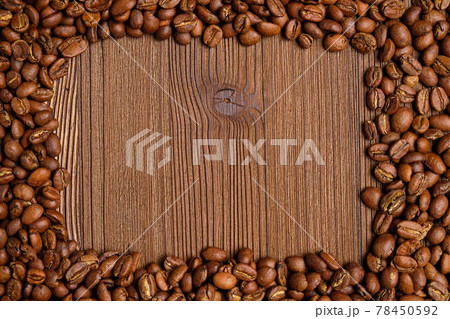 Coffee beans make a frame for a place with text on a wooden background. Coffee beans make a frame for a place with text on a wooden background. 78450592
