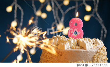 Birthday cake with 8 number pink candles and burning sparkler on blue backgraund. Close-up 78451666