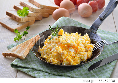 Scrambled eggs served in an iron frying pan 78452138