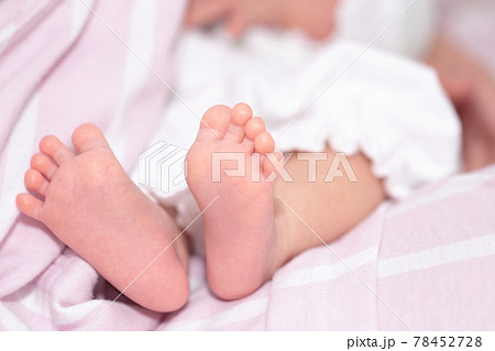 ママに抱っこされた新生児の女の子の足の写真素材