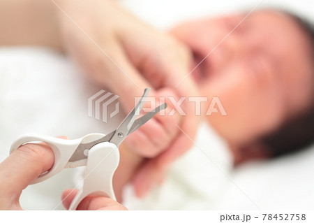 新生児の手の爪切りをするママ 78452758