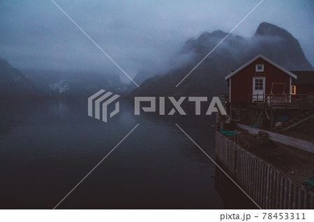 Norway rorbu houses and mountains rocks over fjord landscape scandinavian travel view Lofoten islands. Night landscape. Norway rorbu houses and mountains rocks over fjord landscape scandinavian travel view Lofoten islands. Night landscape. 78453311