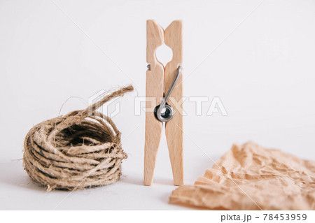 Wooden clothespin with rope and brown paper on white background. Place for your text 78453959