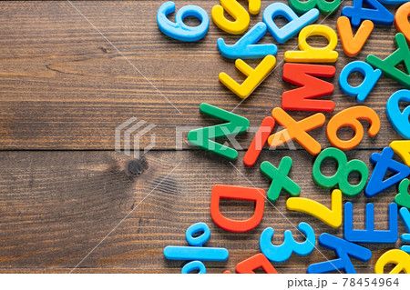 Top view of colorful plastic letters and numbers on wooden background 78454964