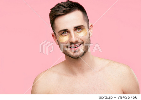 Portrait of smiling handsome man with golden eye patches on pink background Portrait of smiling handsome man with golden eye patches on pink background 78456766