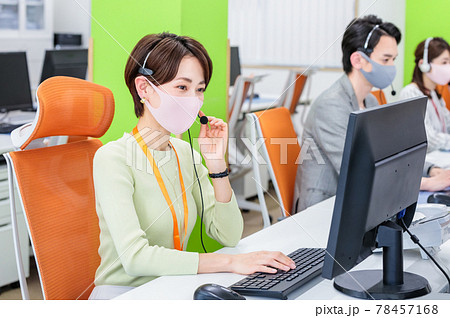 マスクとヘッドセットをつけて働くスタッフ マスクとヘッドセットをつけて働くスタッフ 78457168