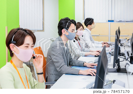 マスクとヘッドセットをつけて働くスタッフ マスクとヘッドセットをつけて働くスタッフ 78457170