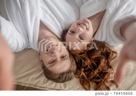 Happy man and woman lying in bed and smiling Happy man and woman lying in bed and smiling 78459808