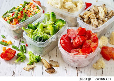 Frozen vegetables. Stocks of food for the winter. Container with frozen vegetables and mushrooms. 78460314