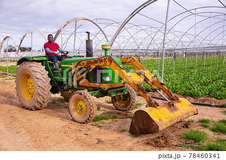 African american man working on garden tractor 78460341