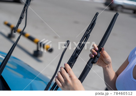 Faceless woman changing car windshield wipers. 78460512