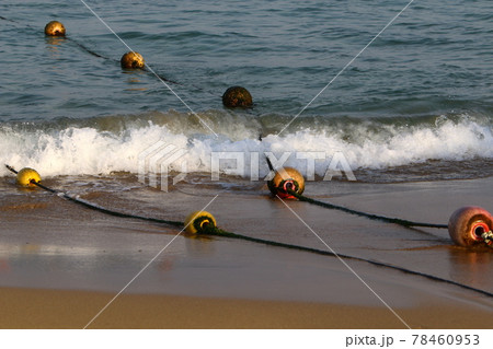 A rope with floating buoys on a sandy beach on the Mediterranean coast. Seashore on a sunny day. A rope with floating buoys on a sandy beach on the Mediterranean coast. Seashore on a sunny day. 78460953