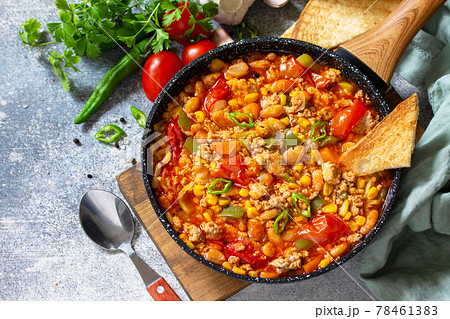 Traditional mexican food. Chili con carne from meat, beans and vegetables on dark stone table. Copy space. 78461383