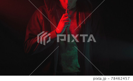 Photo of man with vape in red and green smoke 78462457