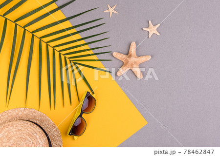 Beach accessories: glasses and hat with shells and sea stars on a colored background. Summer background 78462847