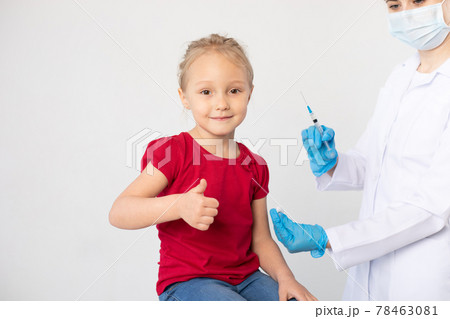 Woman doctor with a syringe and child showing thumb up. Woman doctor with a syringe and child showing thumb up. 78463081