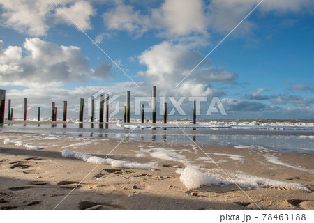 Petten, the Netherlands. March 3, 2021. Wooden poles at the beach near Petten aan Zee, the Netherlands. 78463188