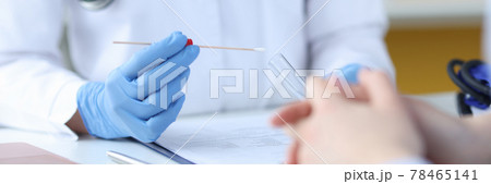A doctor in protective gloves holds a test tube in front of a patient A doctor in protective gloves holds a test tube in front of a patient 78465141